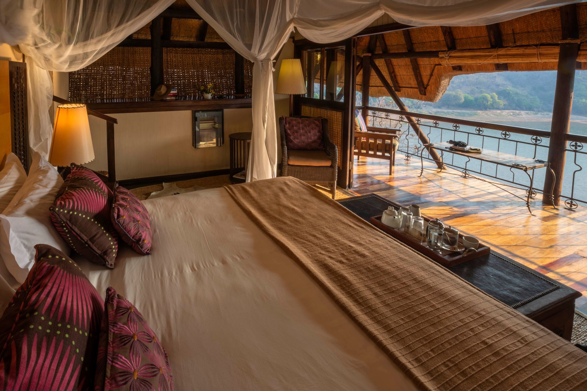 A bedroom with a canopy bed and a view of the water.
