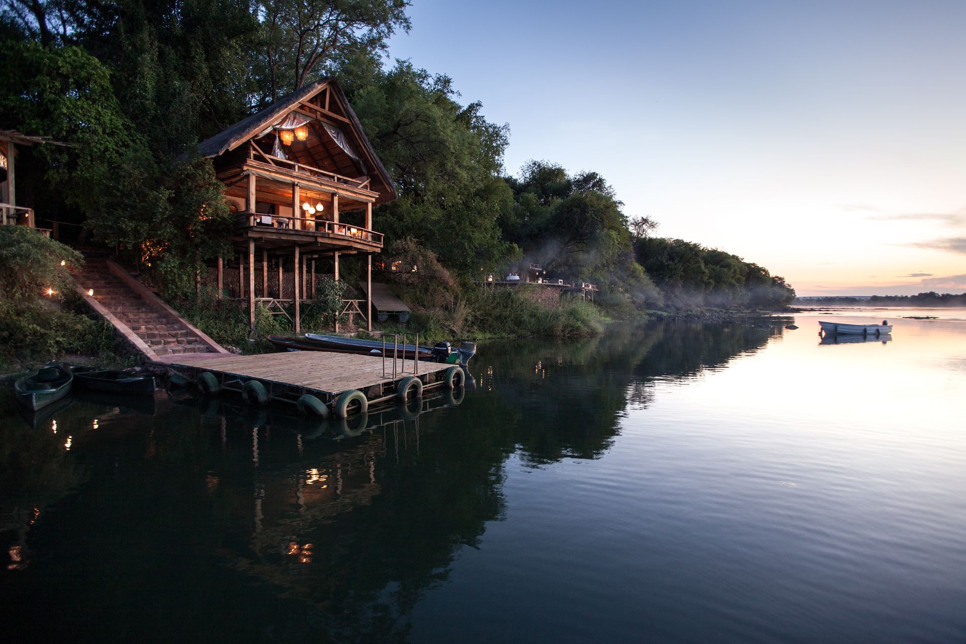 A bedroom with a canopy bed and a swimming pool in the background.