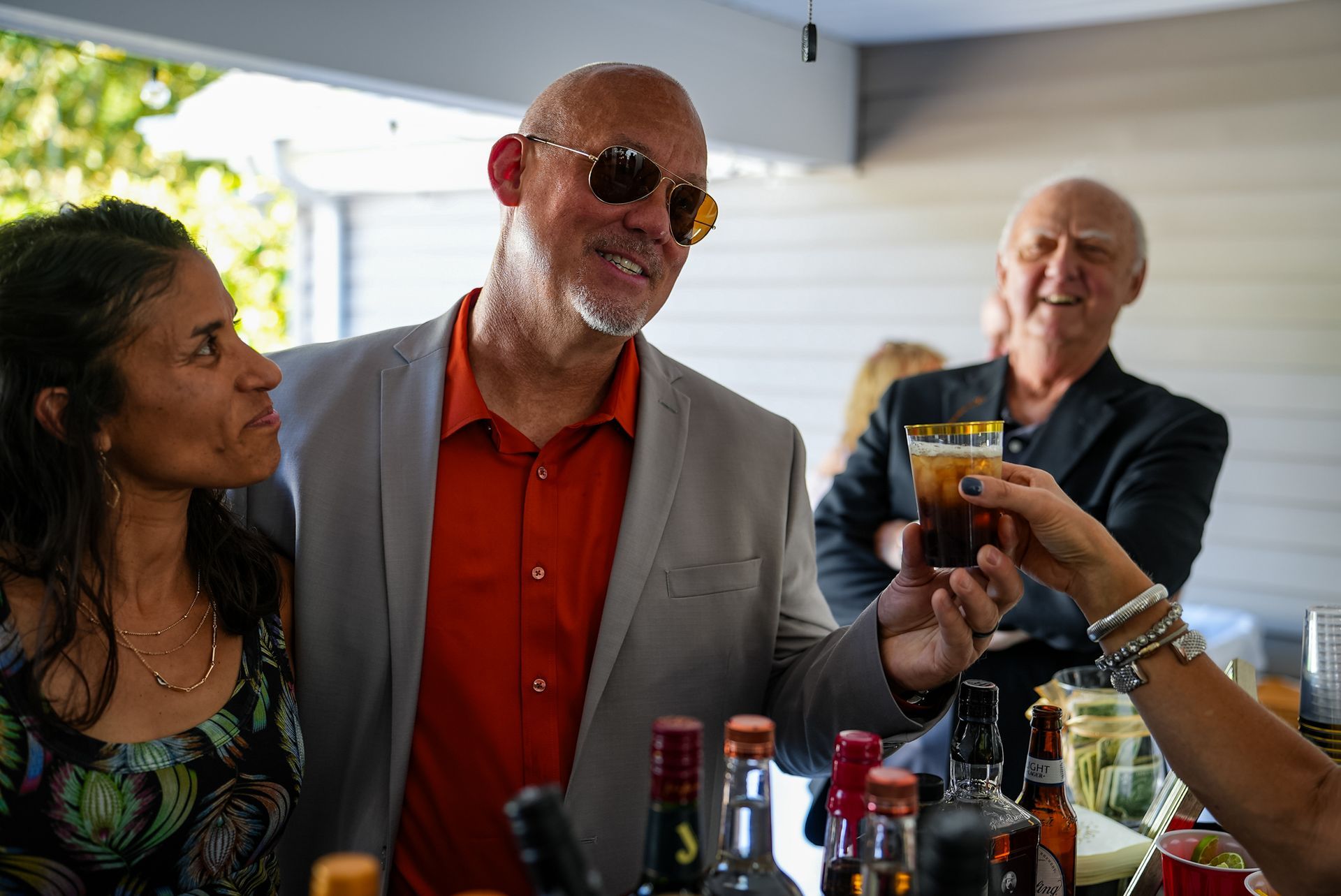 A group of people are toasting with drinks at a party.