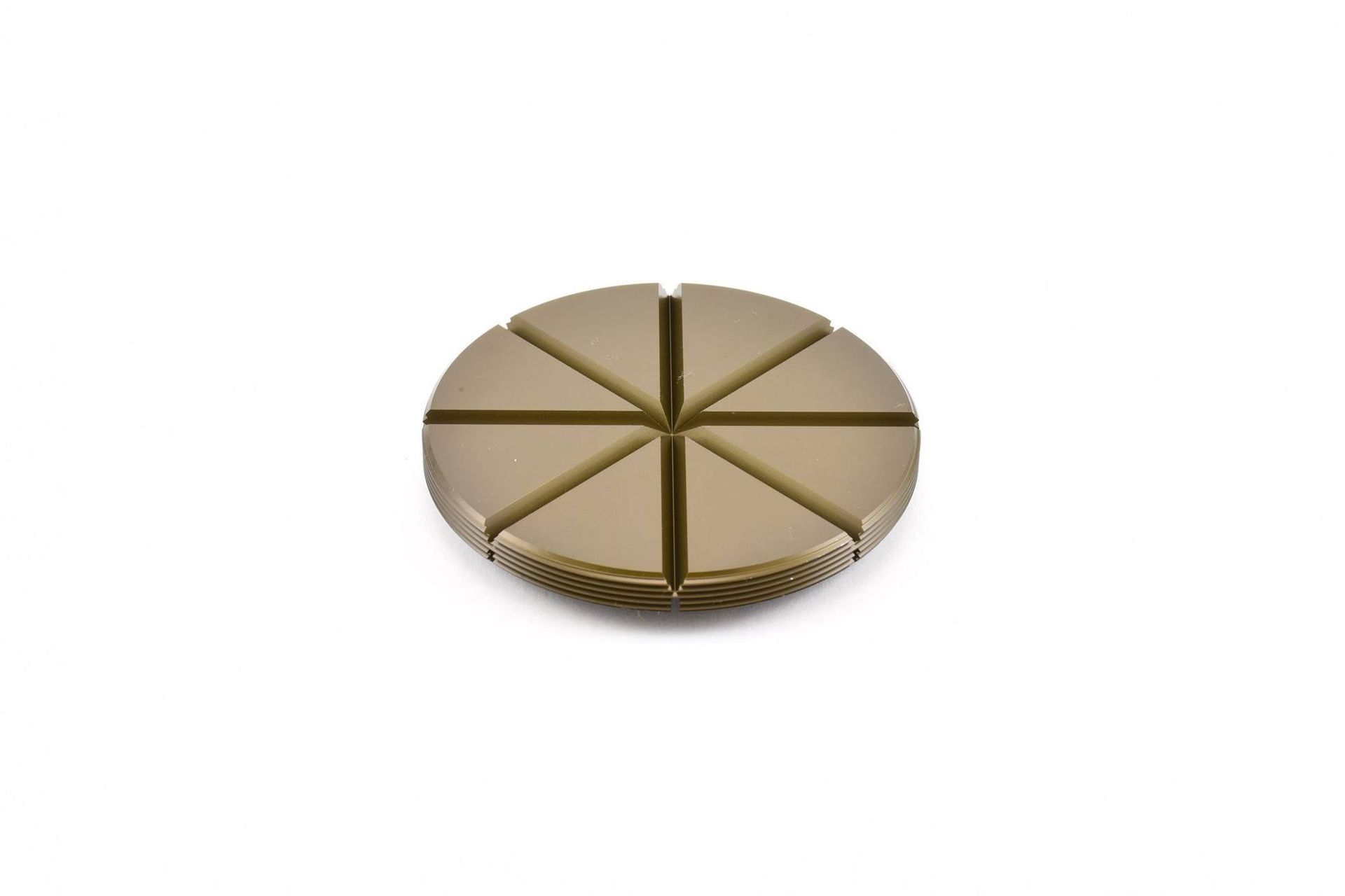 Gold-colored circular object divided into eight triangular segments by grooves.