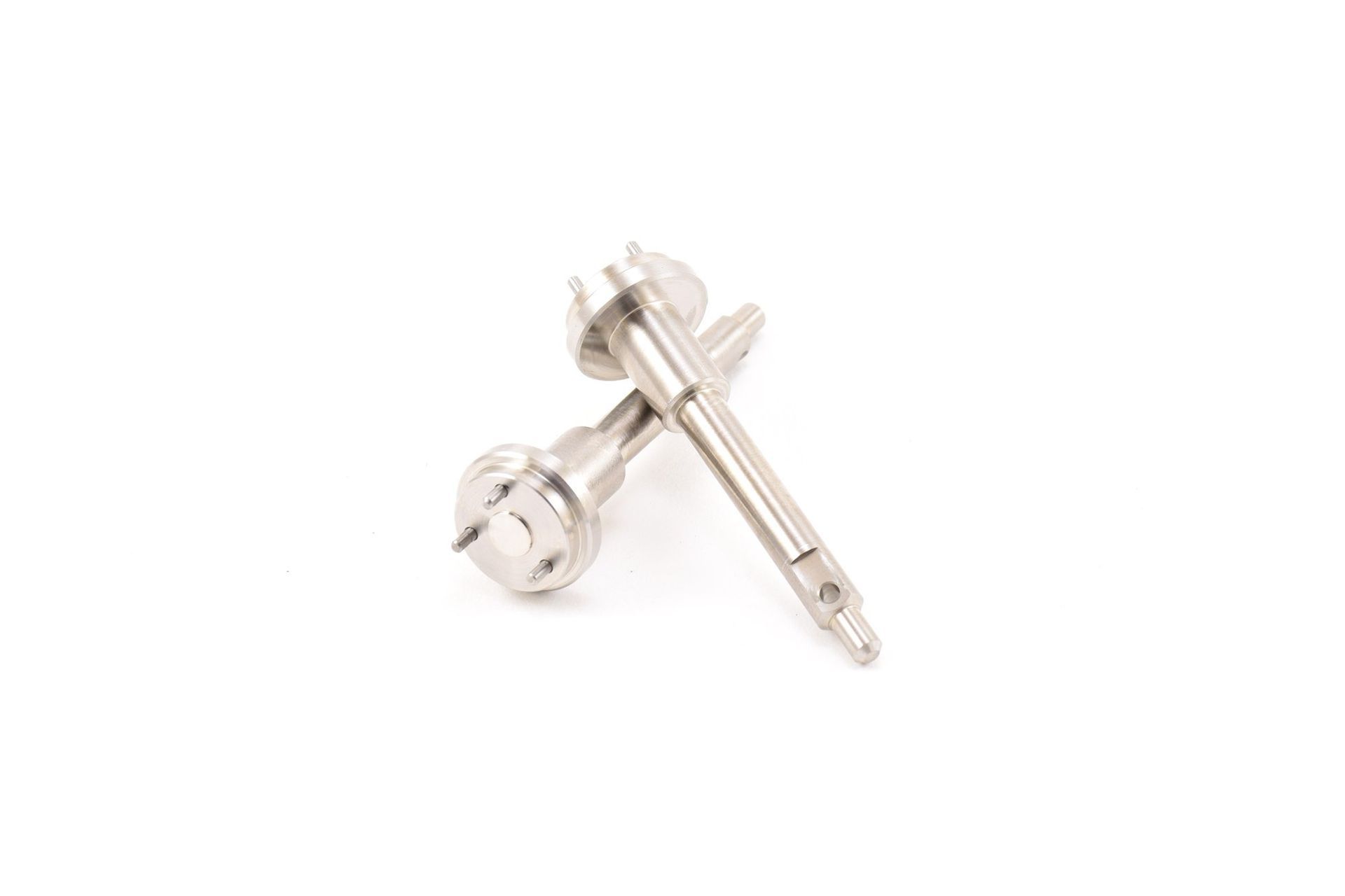 Two metallic, cylindrical machine components on a white background. One is lying across the other.