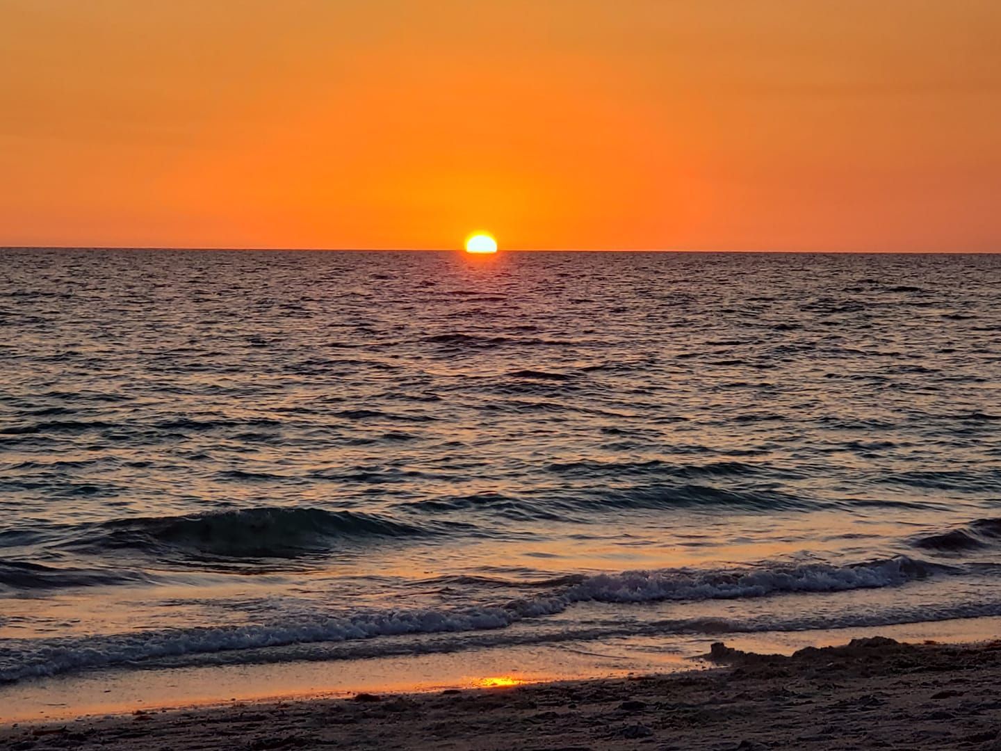 The sun is setting over the ocean.