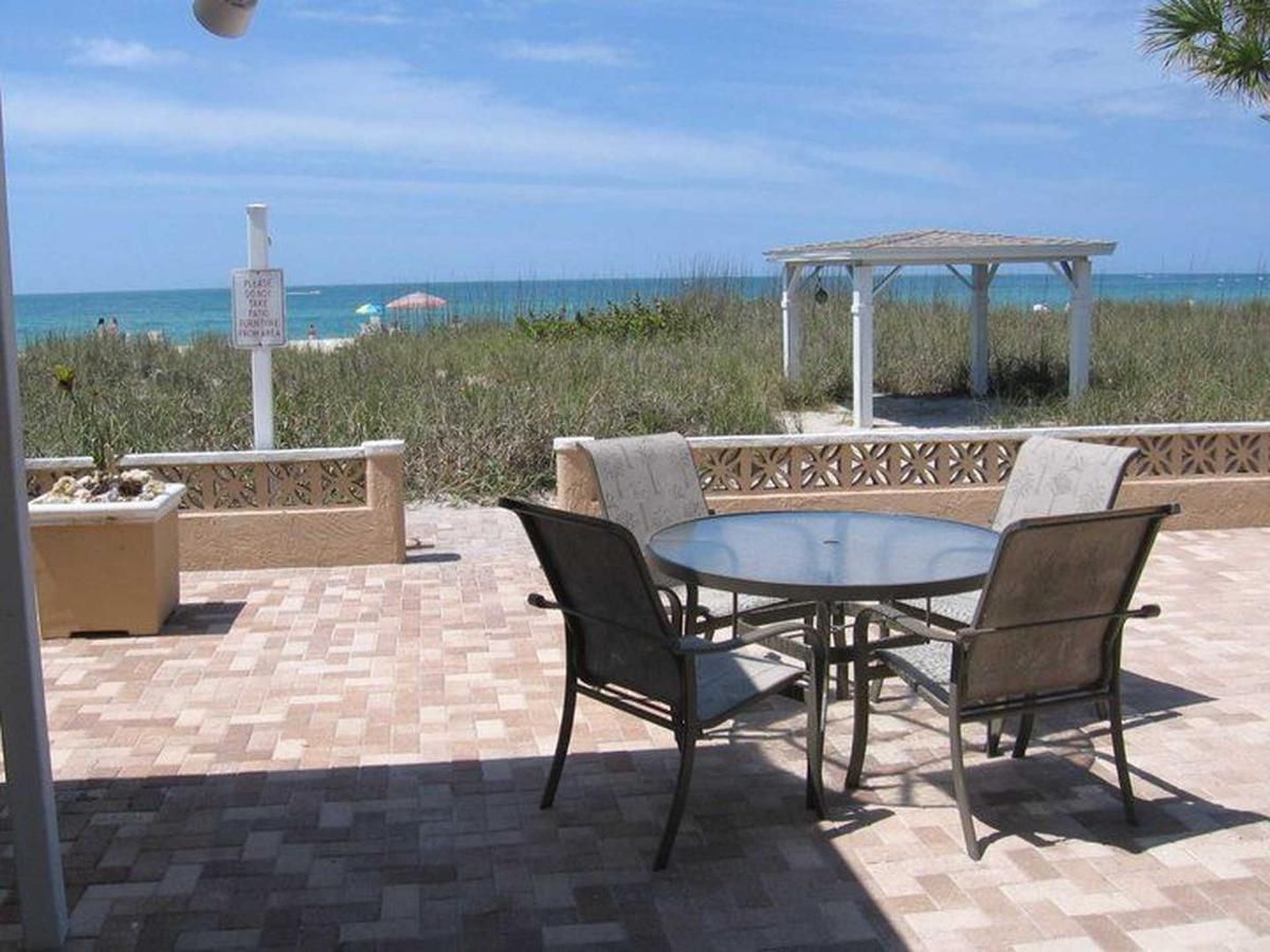 A table and chairs on a patio overlooking the ocean