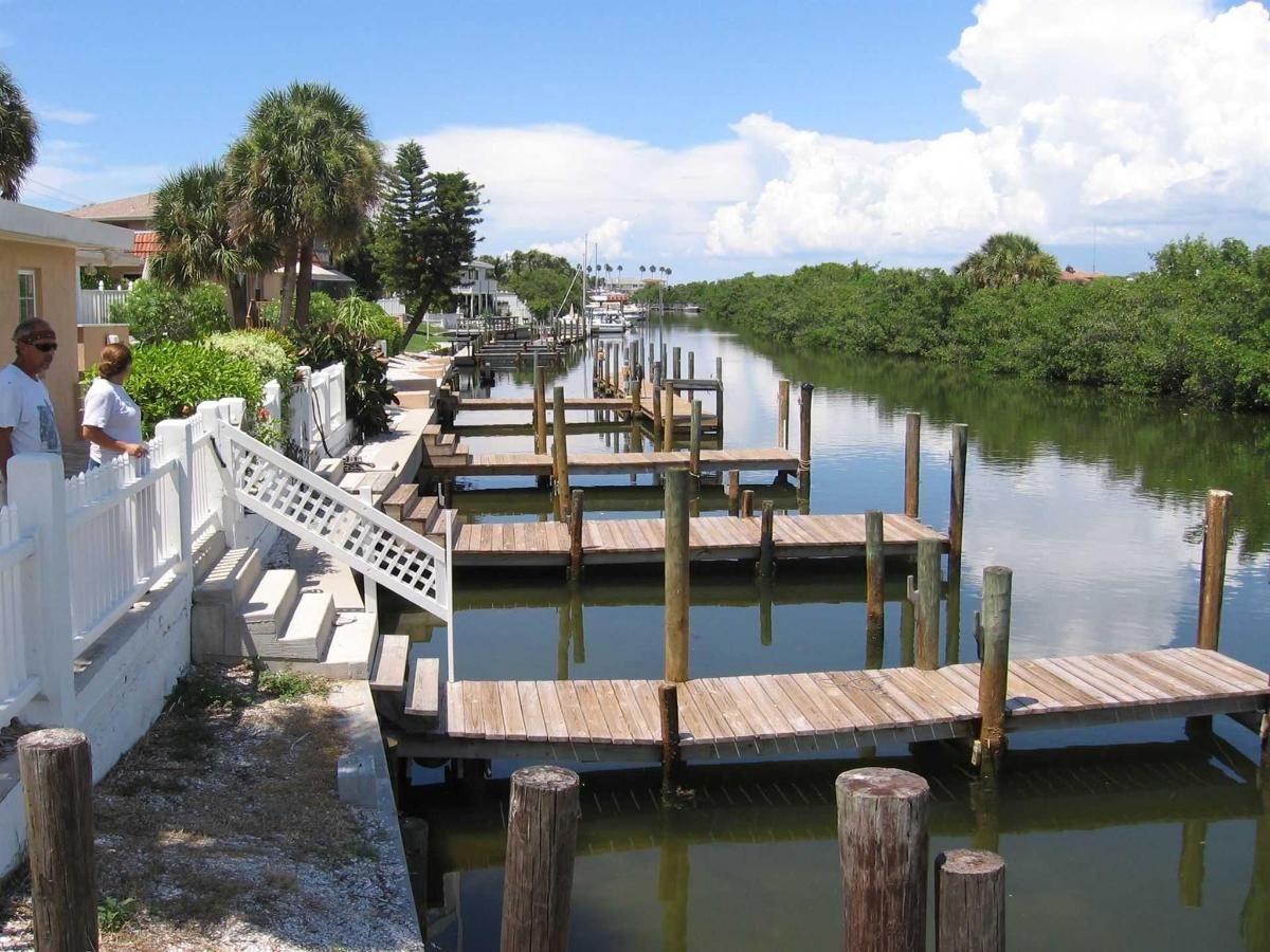 A couple of men standing on a dock overlooking a body of water