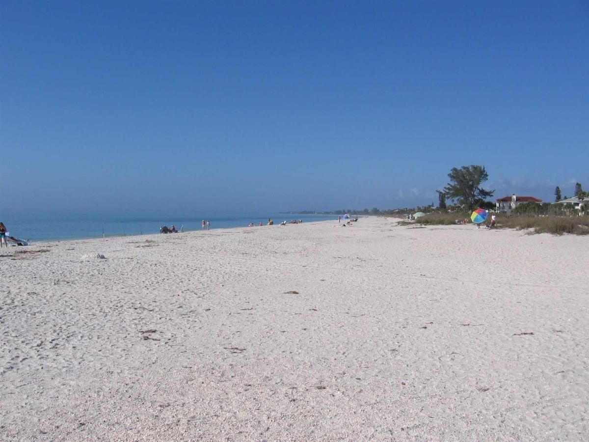 A white sandy beach with a blue sky in the background