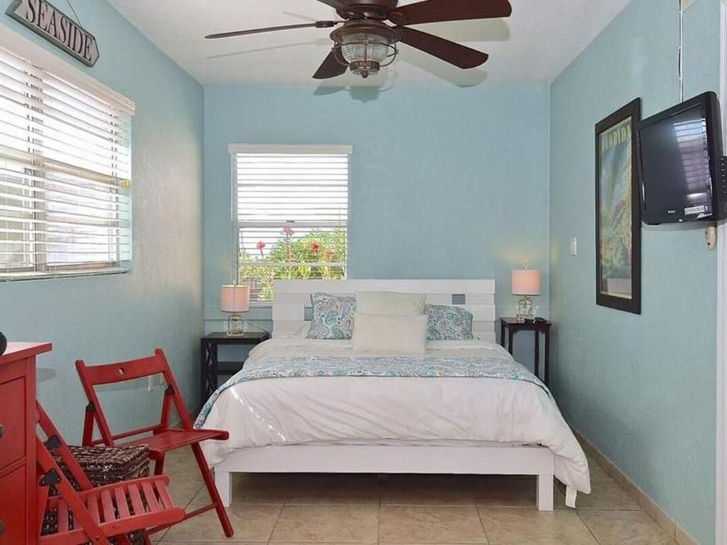 A bedroom with a bed and a ceiling fan