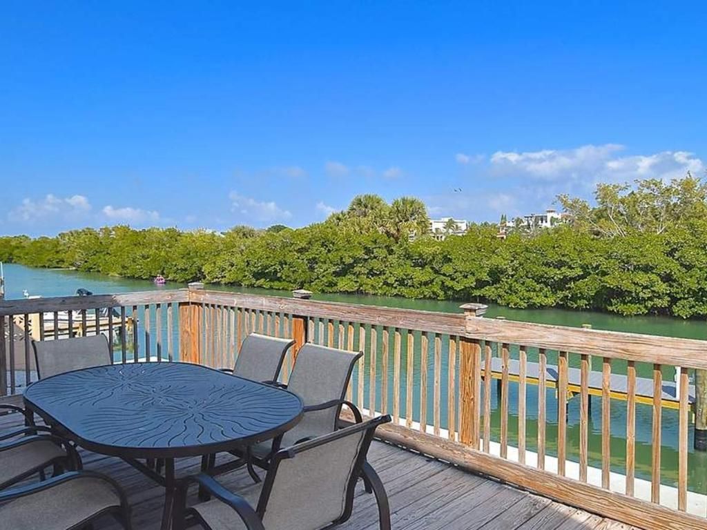 There is a table and chairs on the deck overlooking the water.