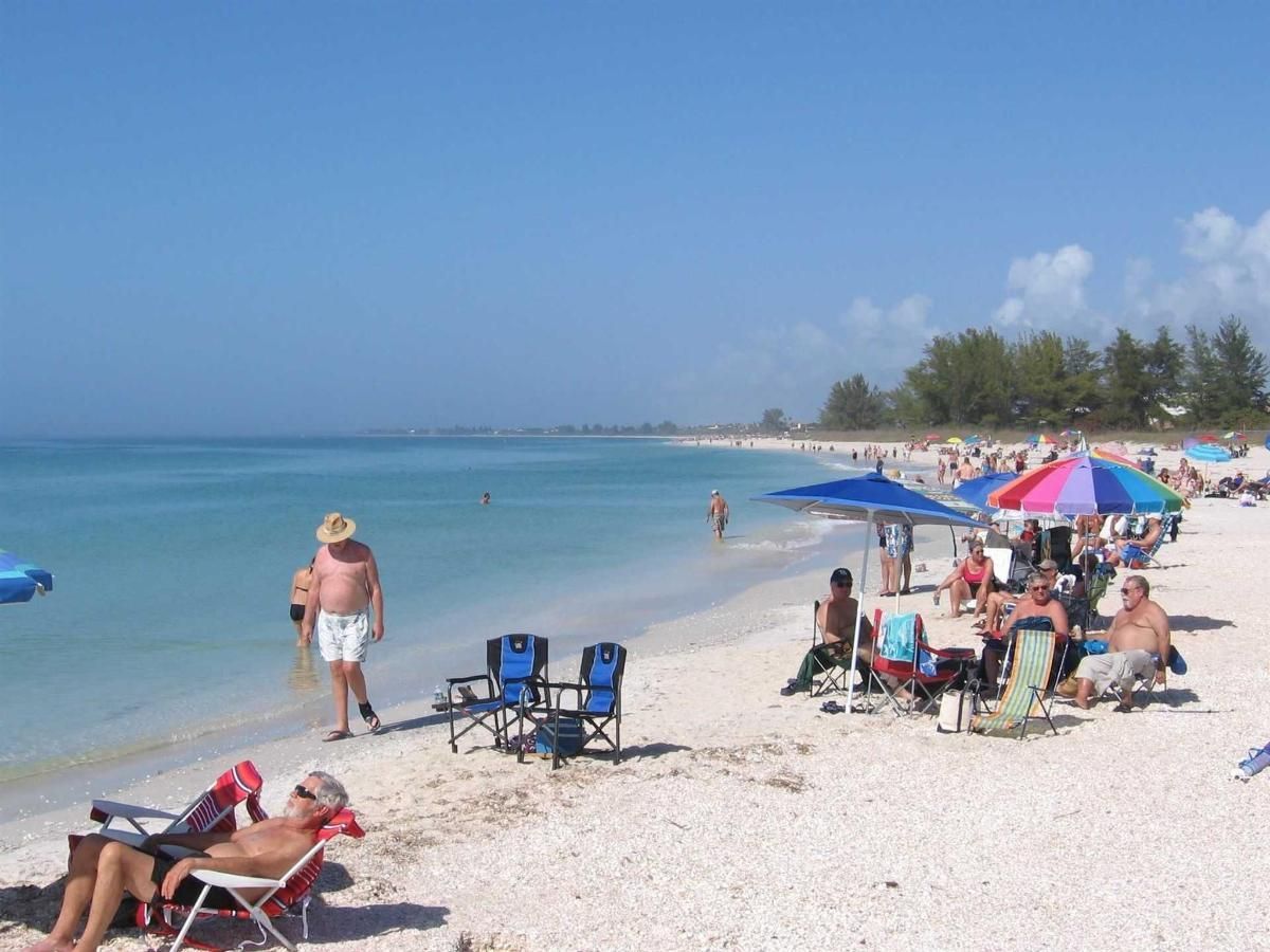 A beach with a lot of people and umbrellas