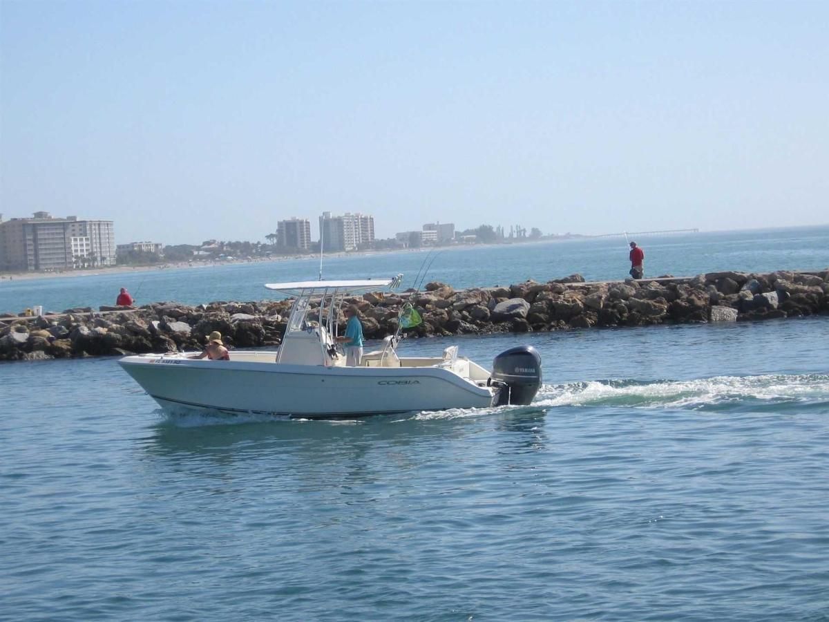 A white boat is floating on top of a body of water.
