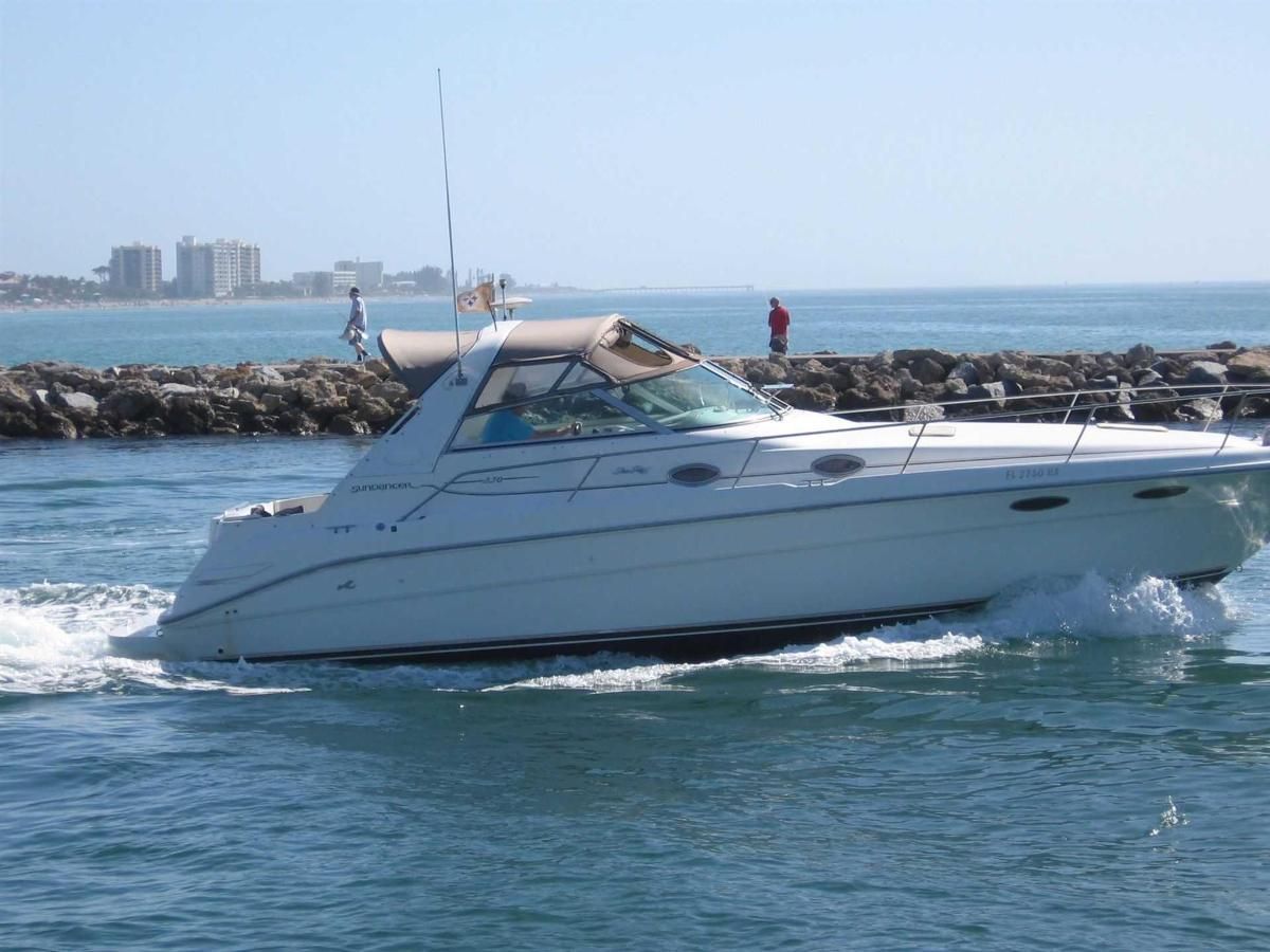 A white boat is floating on top of a body of water