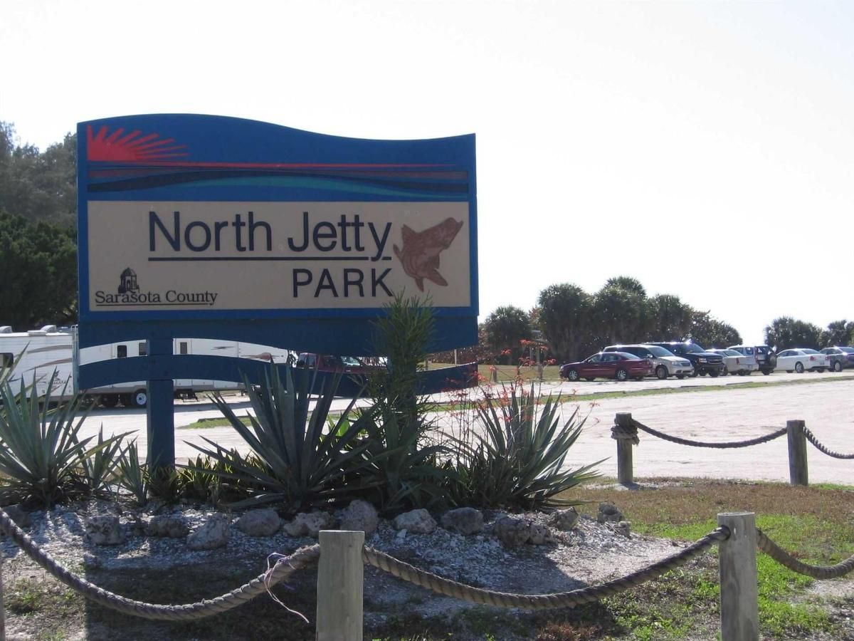 A blue and white sign for north jetty park