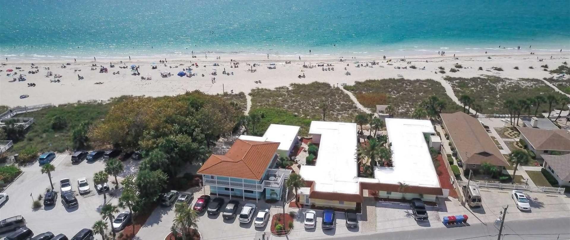 An aerial view of a beach with cars parked in front of it