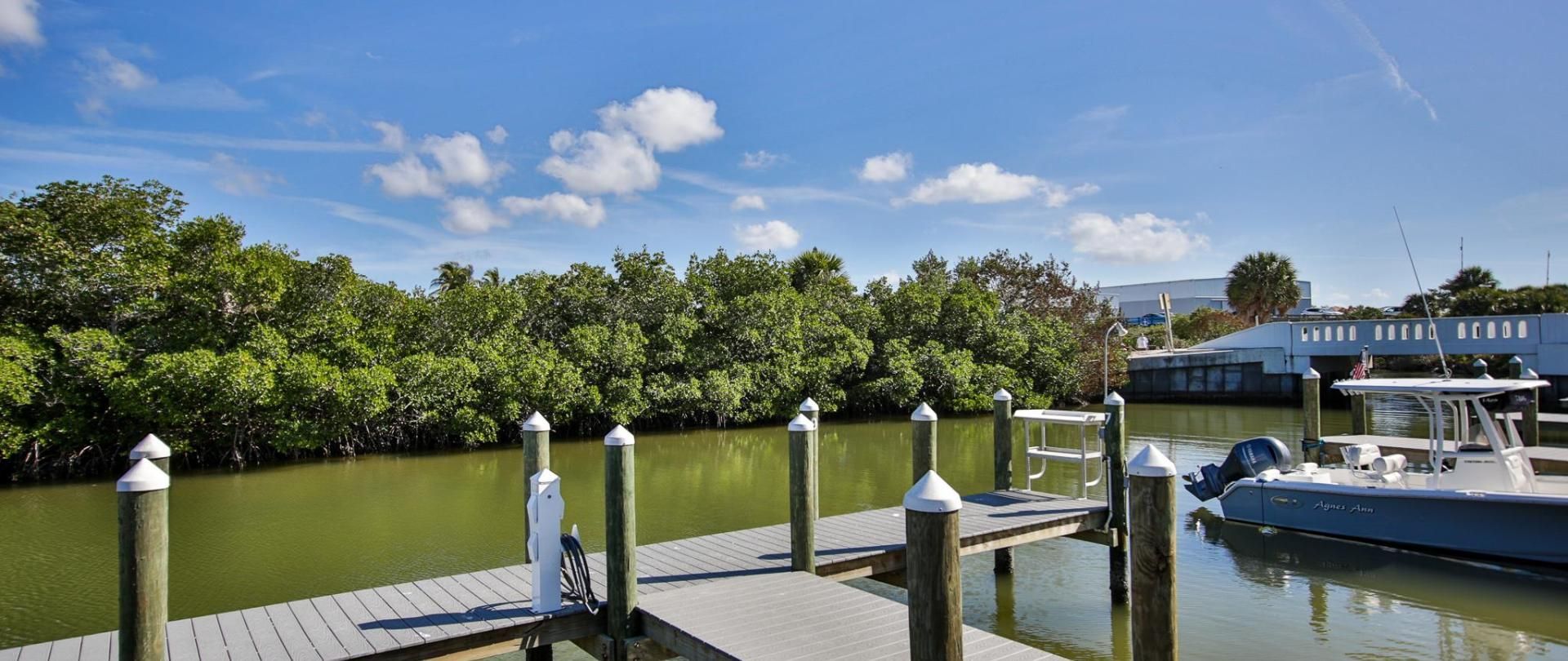 A boat is docked at a dock next to a body of water.