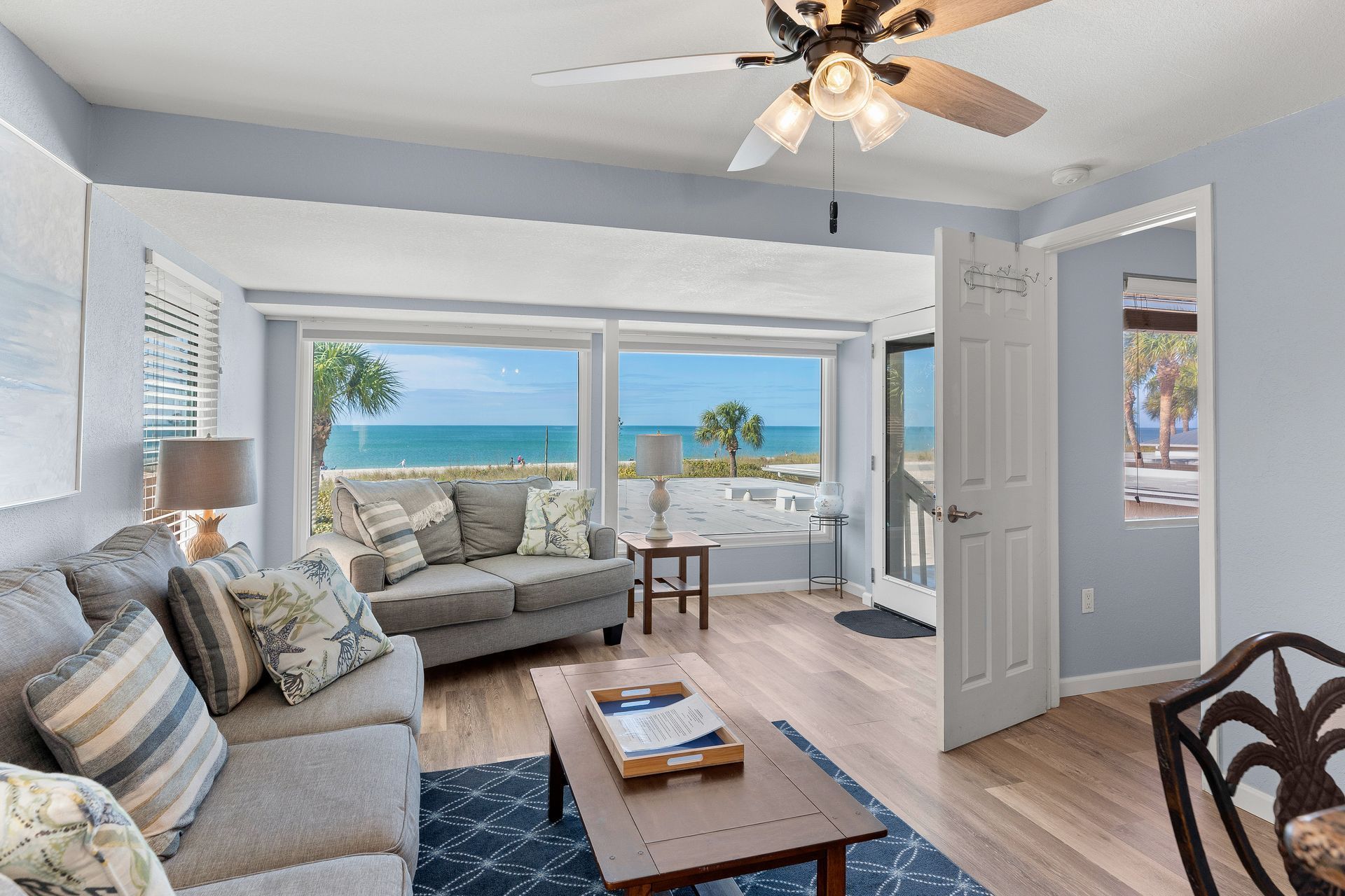 A living room with a couch, coffee table, and ceiling fan.