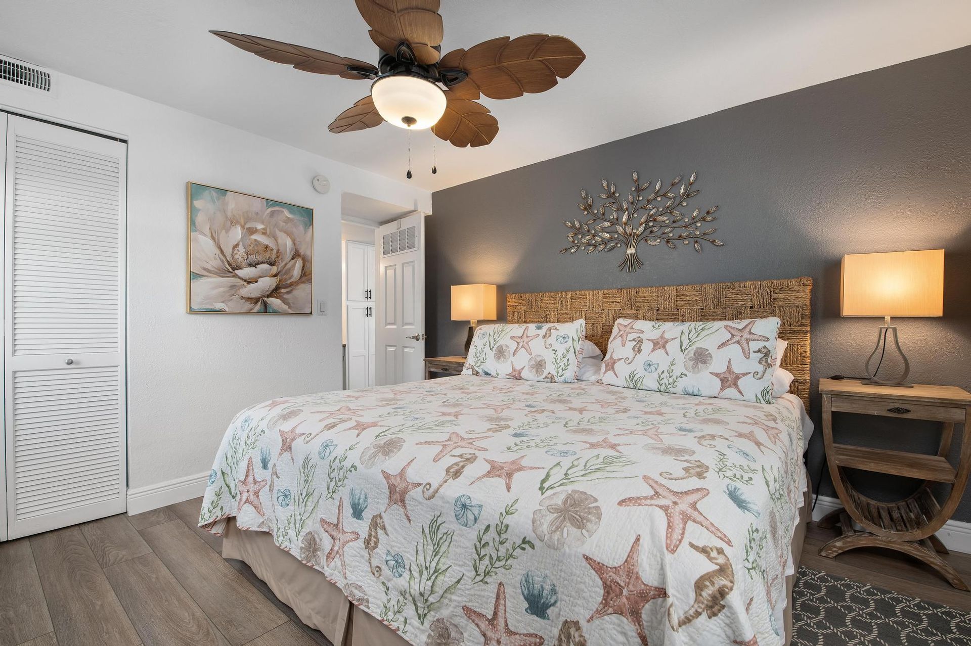 A bedroom with a king size bed and a ceiling fan.