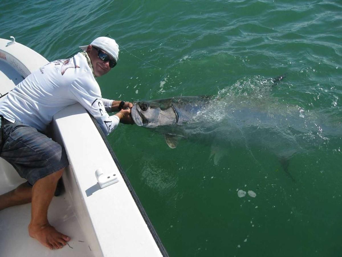 A man on a boat with a fish in his hand