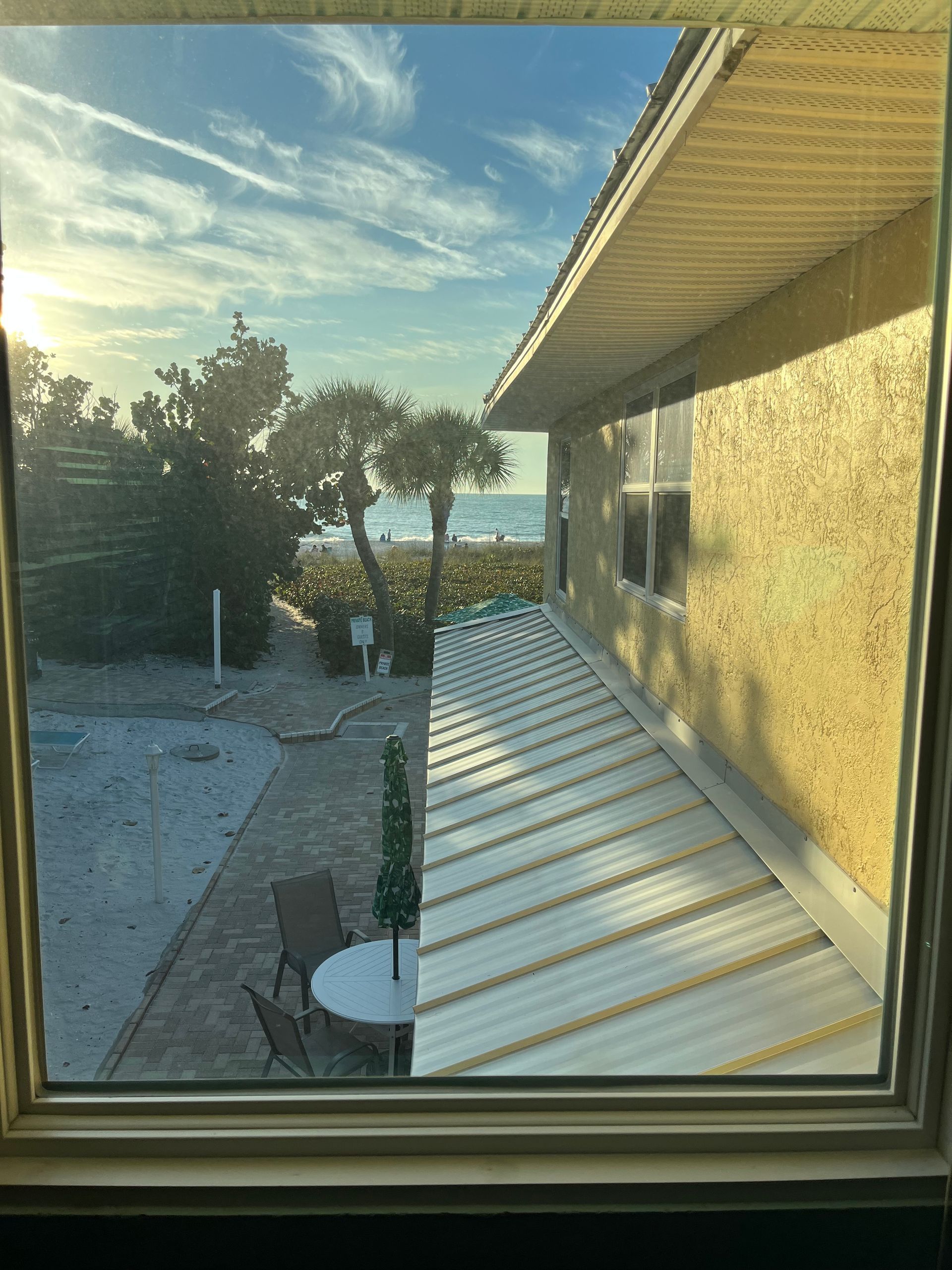 A view of the ocean from a window of a house.