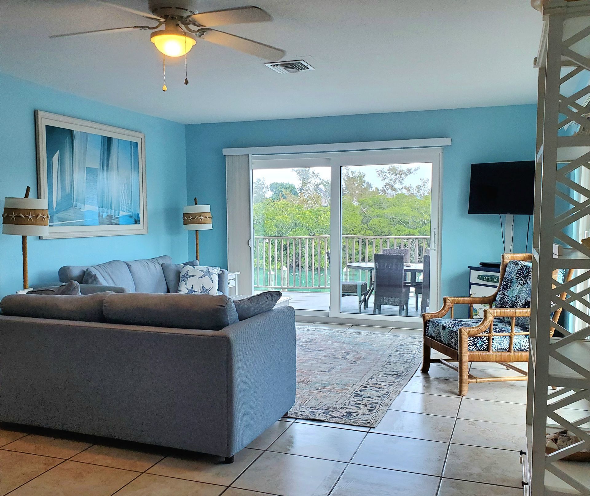 A living room with blue walls and a ceiling fan