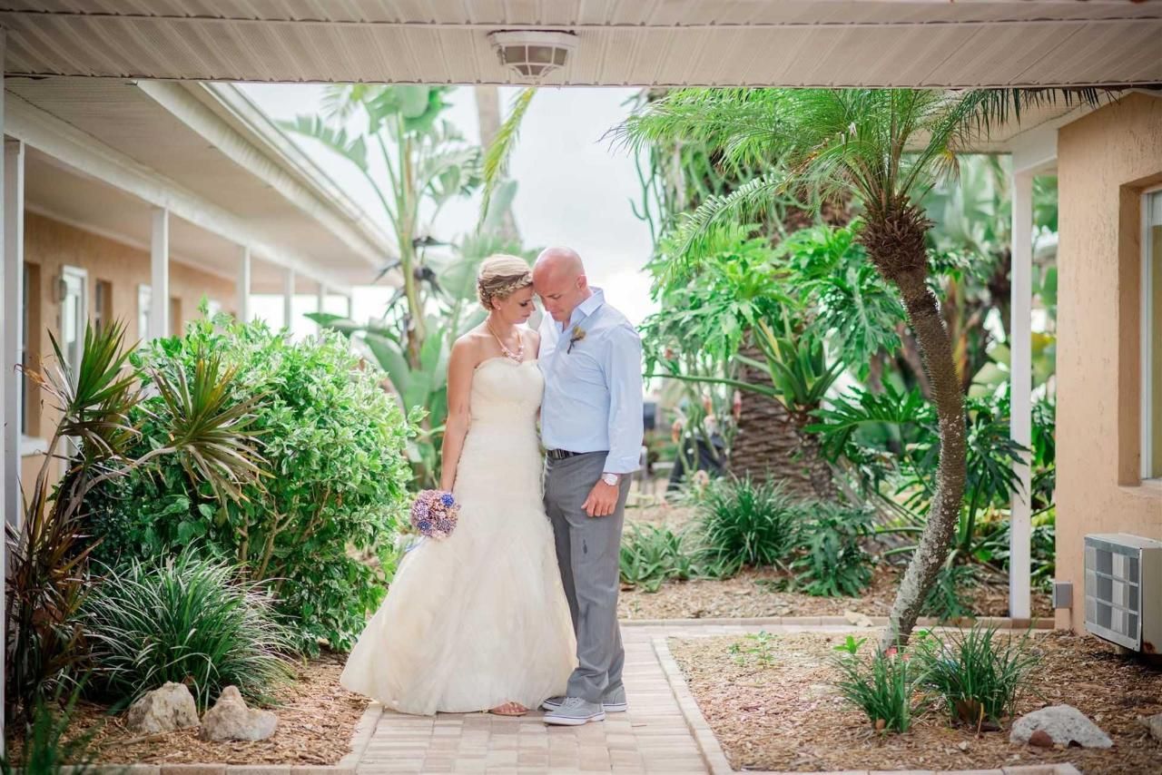 A bride and groom are posing for a picture in front of a building.