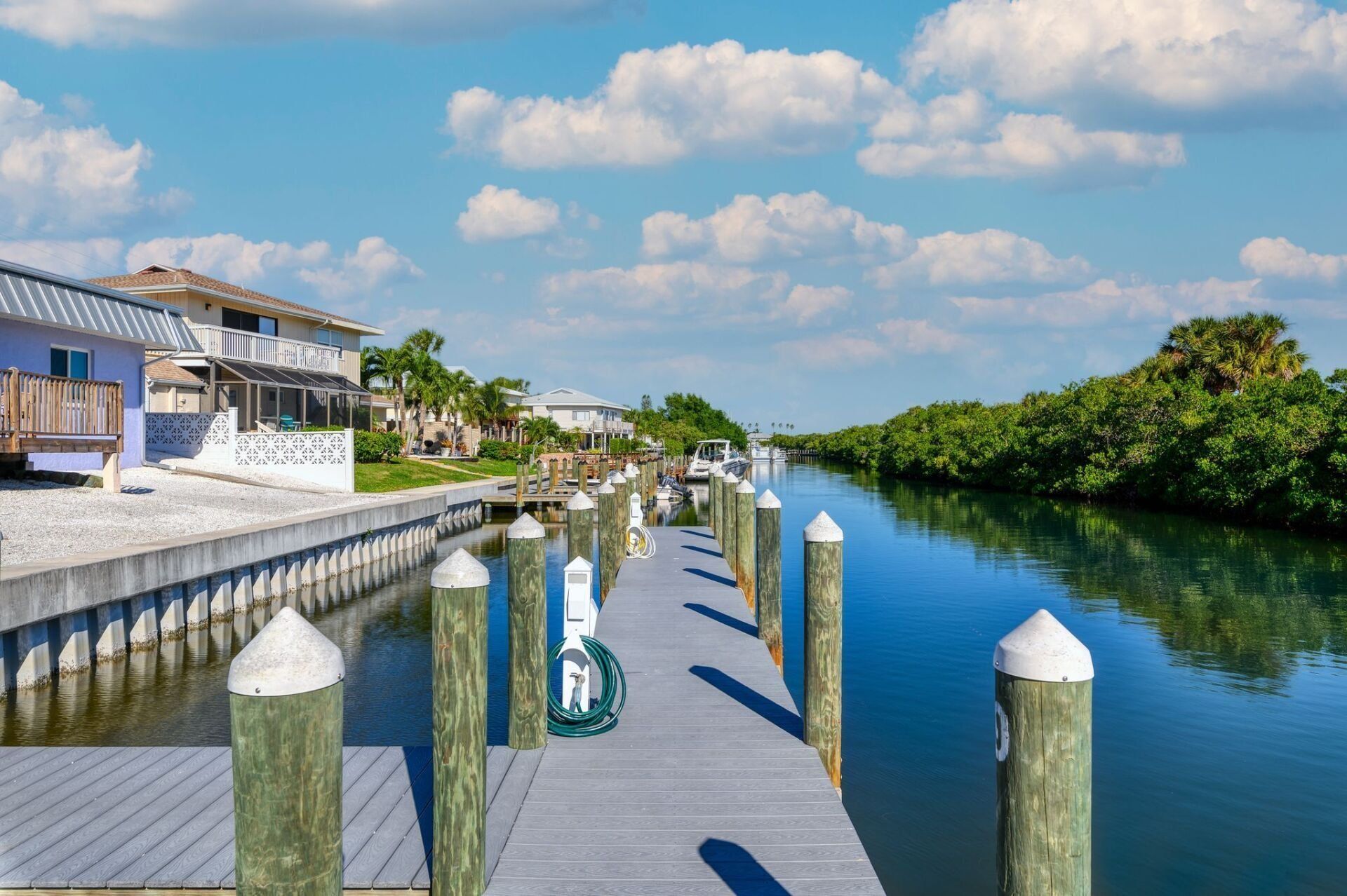 A dock along a river with a house in the background