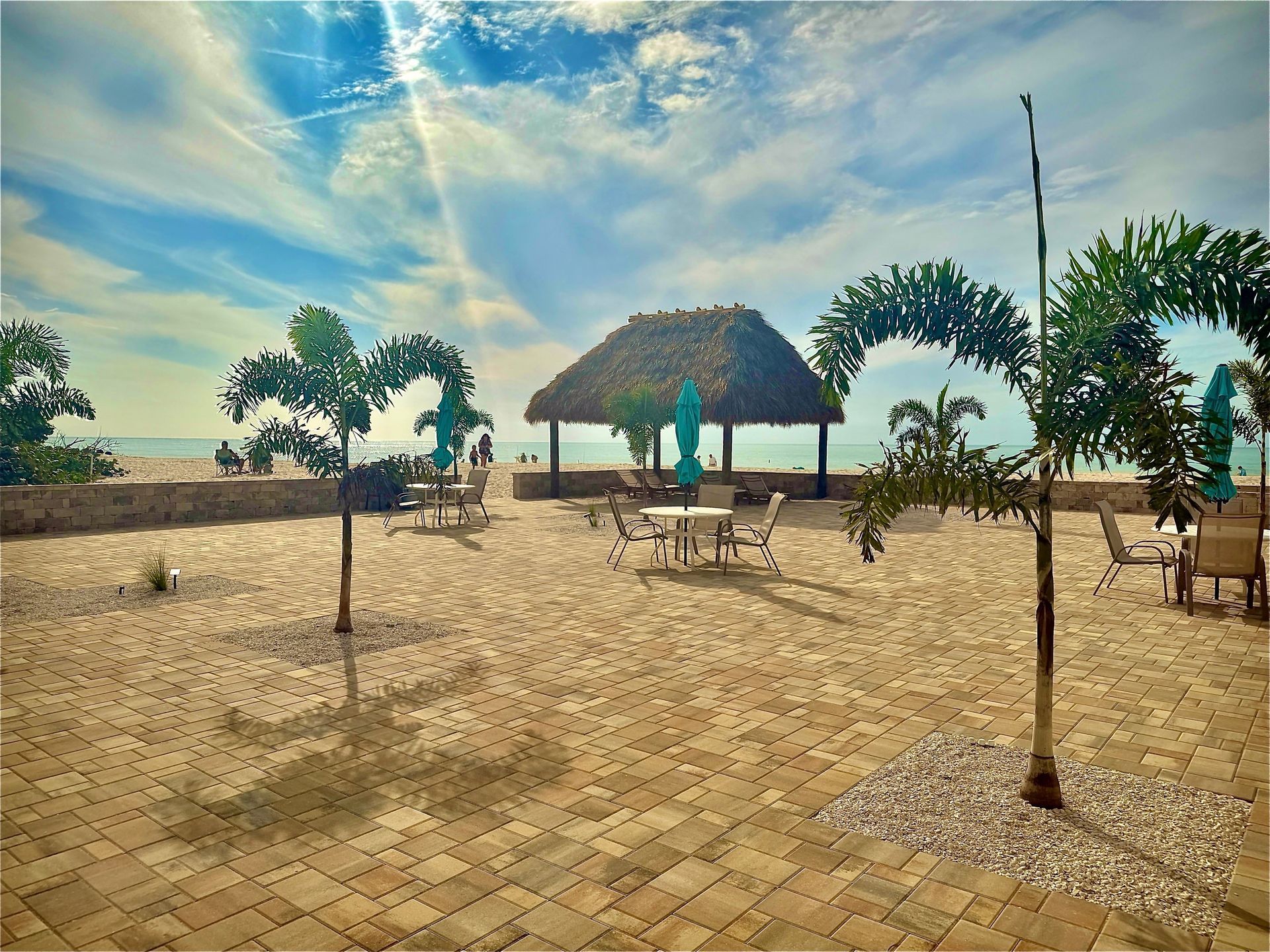 A patio with a table and chairs and an umbrella in front of a yellow house