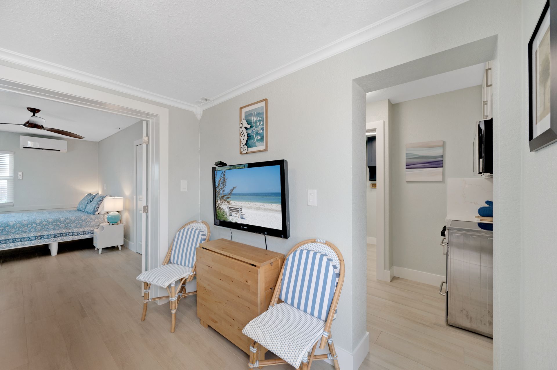 A living room with two chairs and a flat screen tv on the wall.