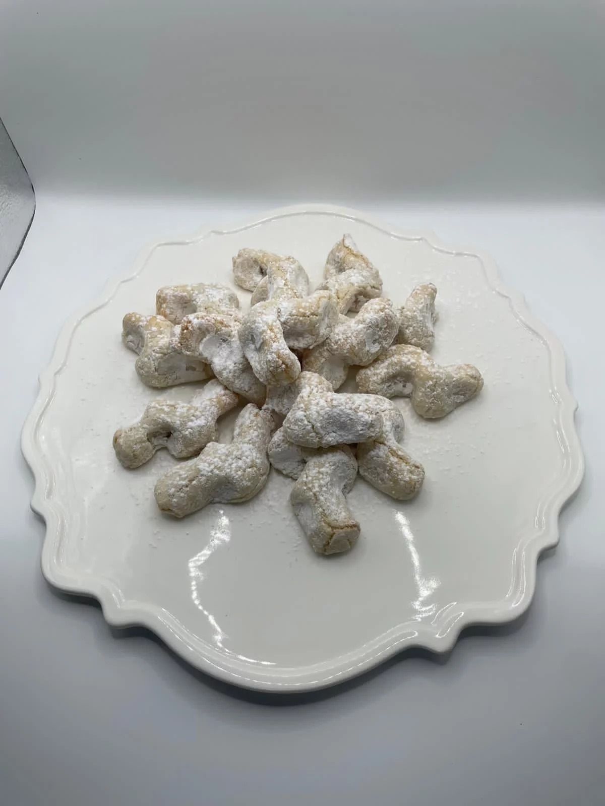 Dolcetto al cioccolato bianco con noci, avvolto in un nastro blu e con una nappa, confezione regalo.