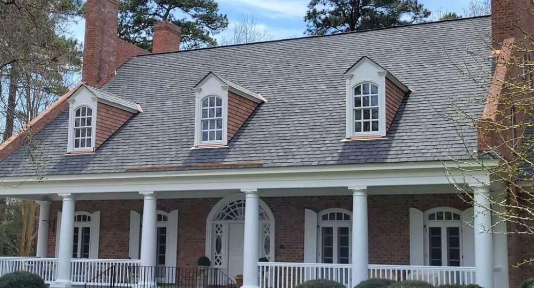 Remodeling: A large brick house with a porch and a slate roof.