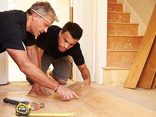 Waterproof Vinyl Installation — Two Men Laying Wood Panel Flooring in Staten Island, NY