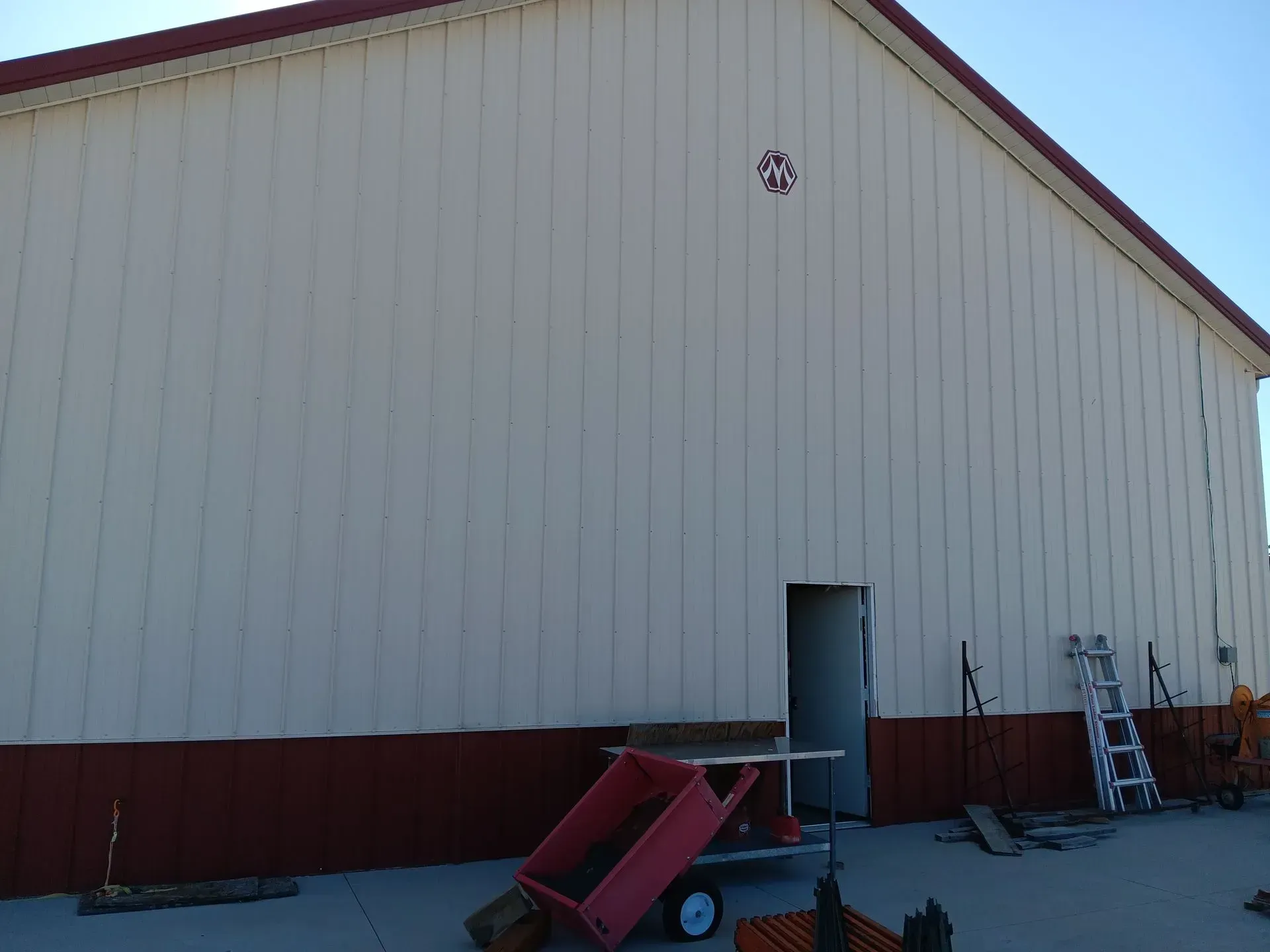 A white building with a red trim and a ladder