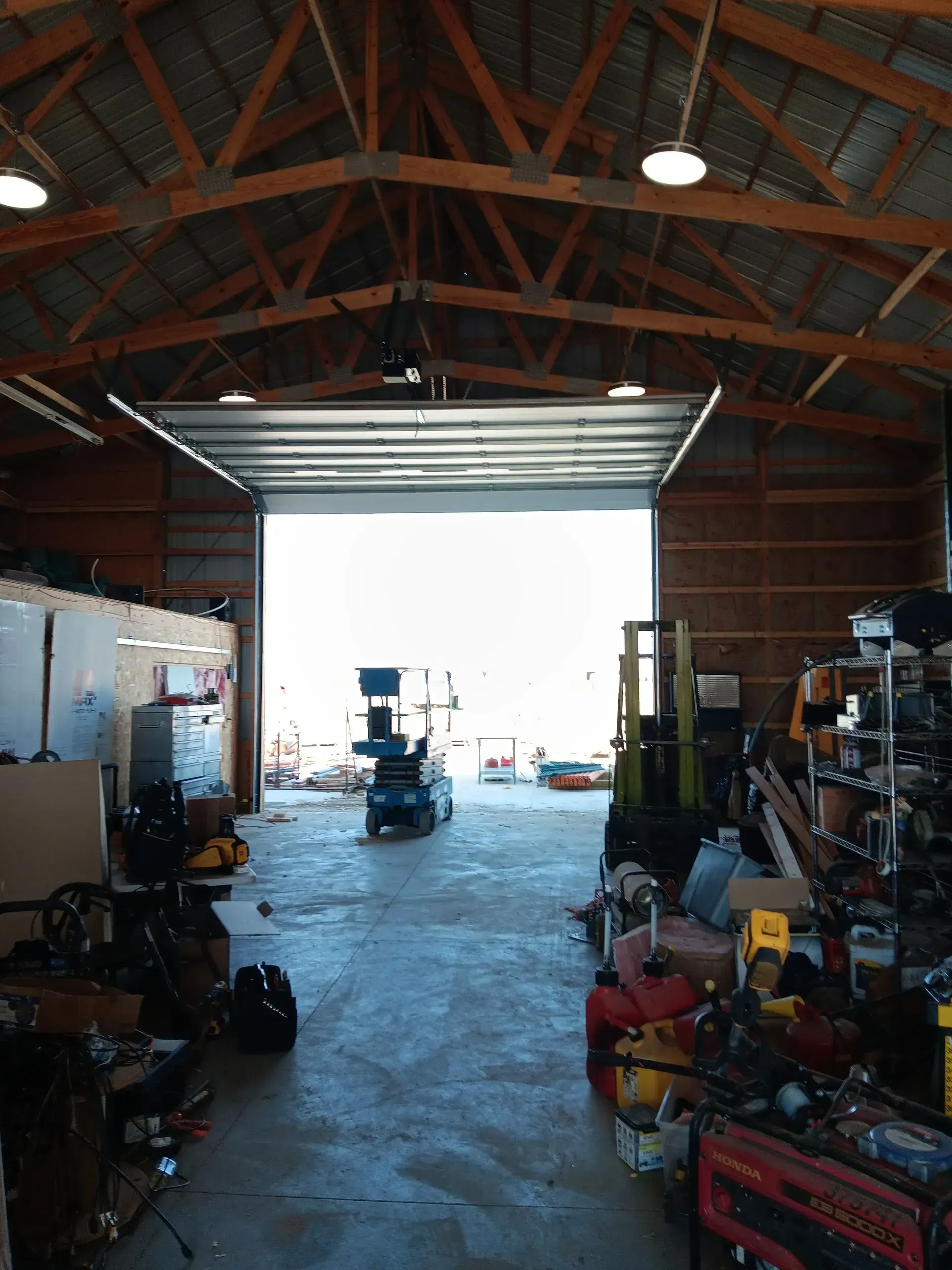 The inside of a garage with a large garage door open