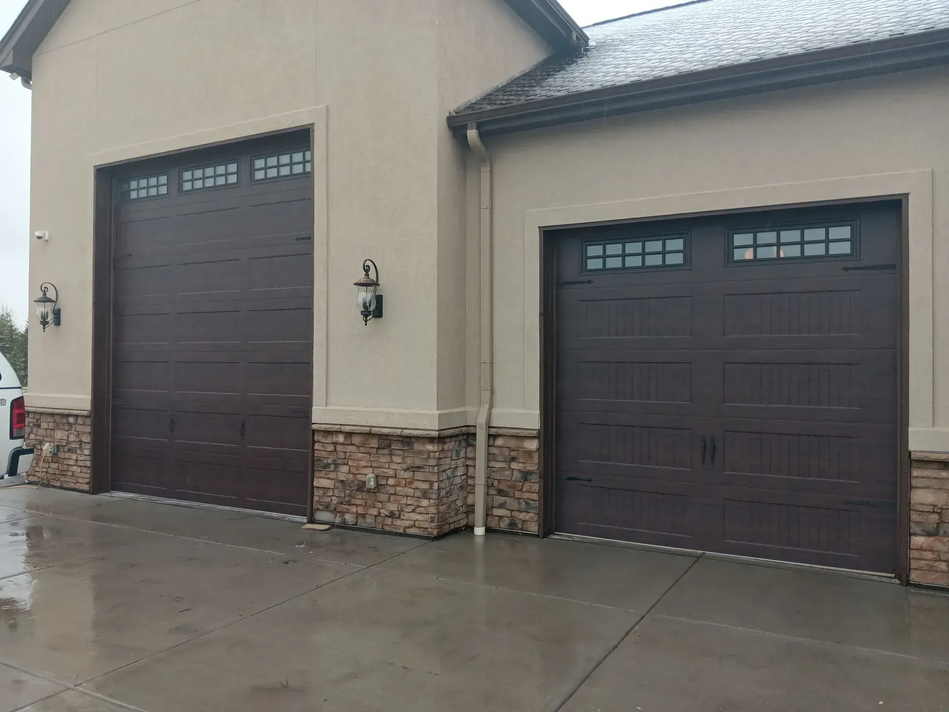 There are two garage doors on the side of a building.