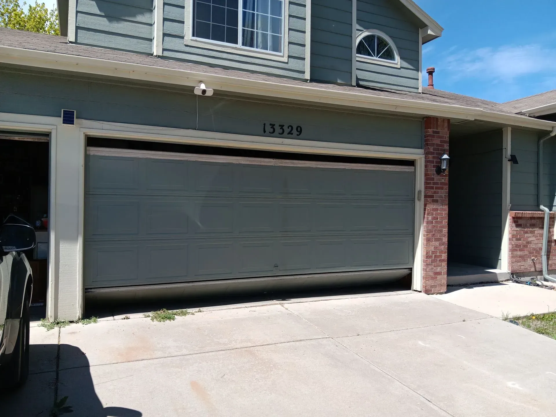 A garage door is open in front of a house.