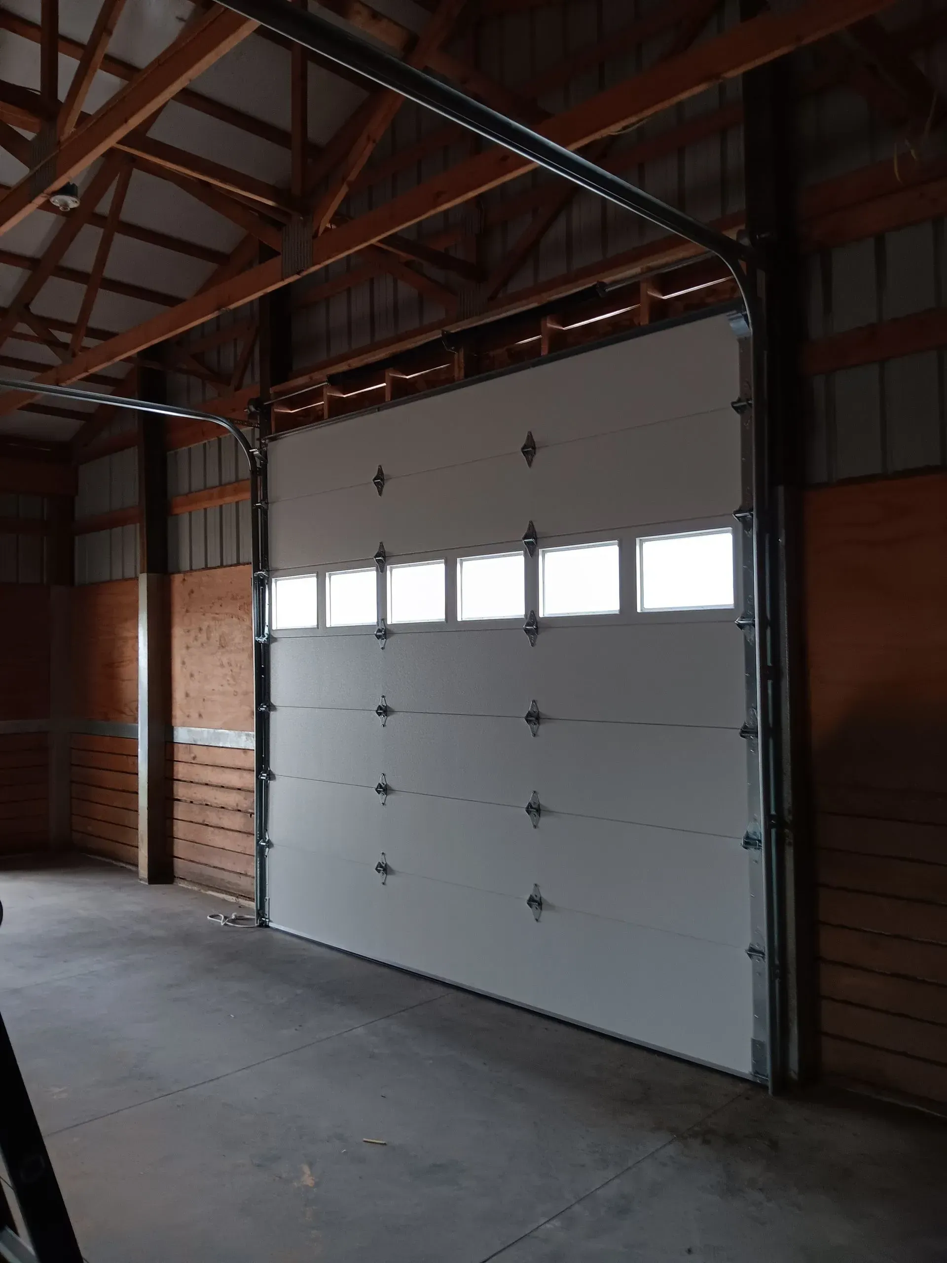 A large white garage door is open in a building