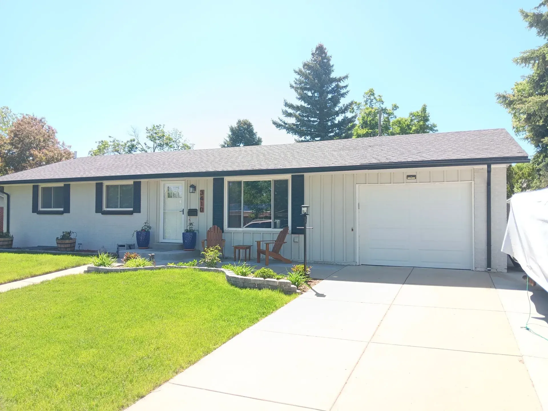A white house with black shutters and a white garage door
