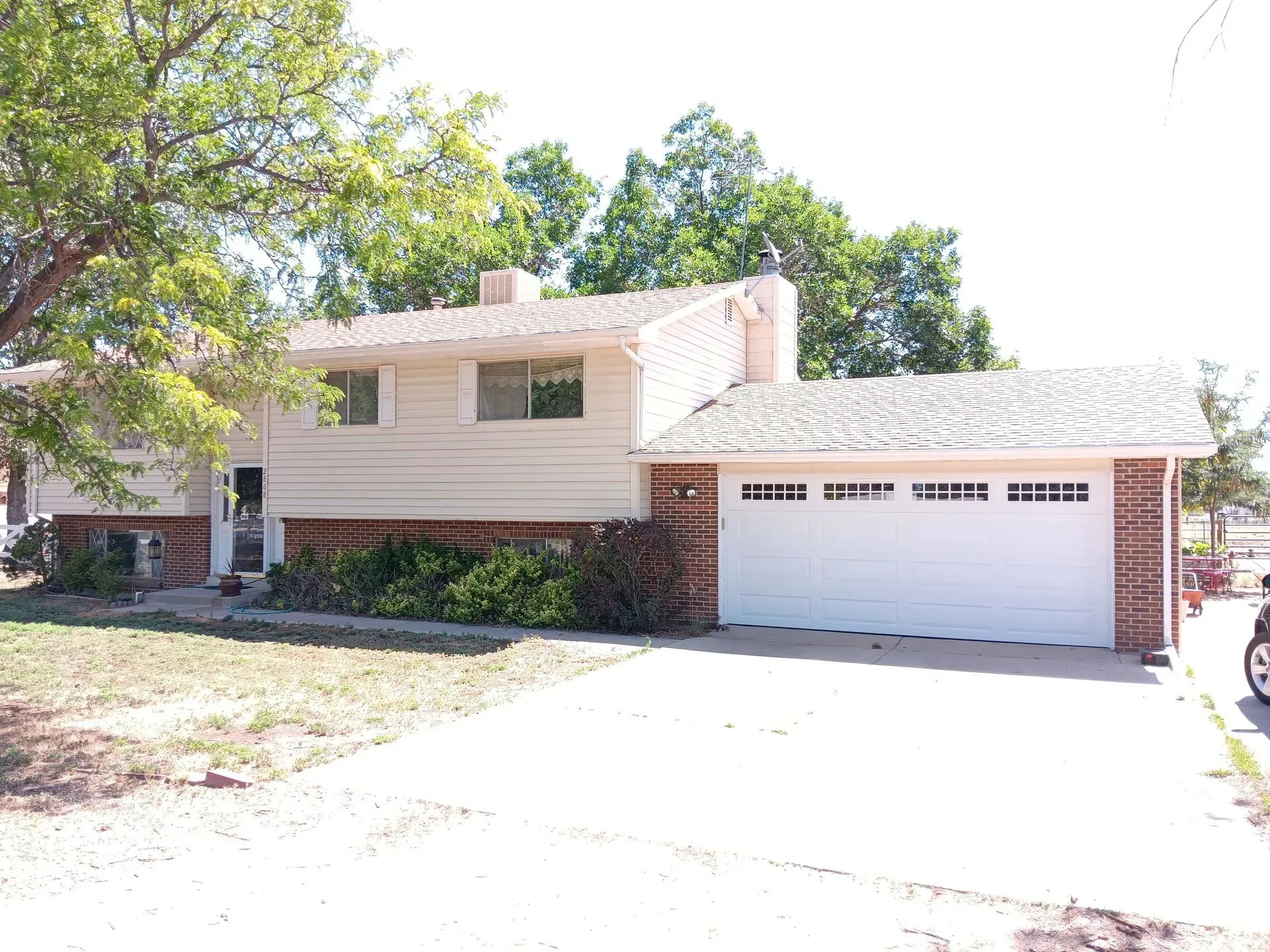 A house with a white garage door and a car parked in front of it.
