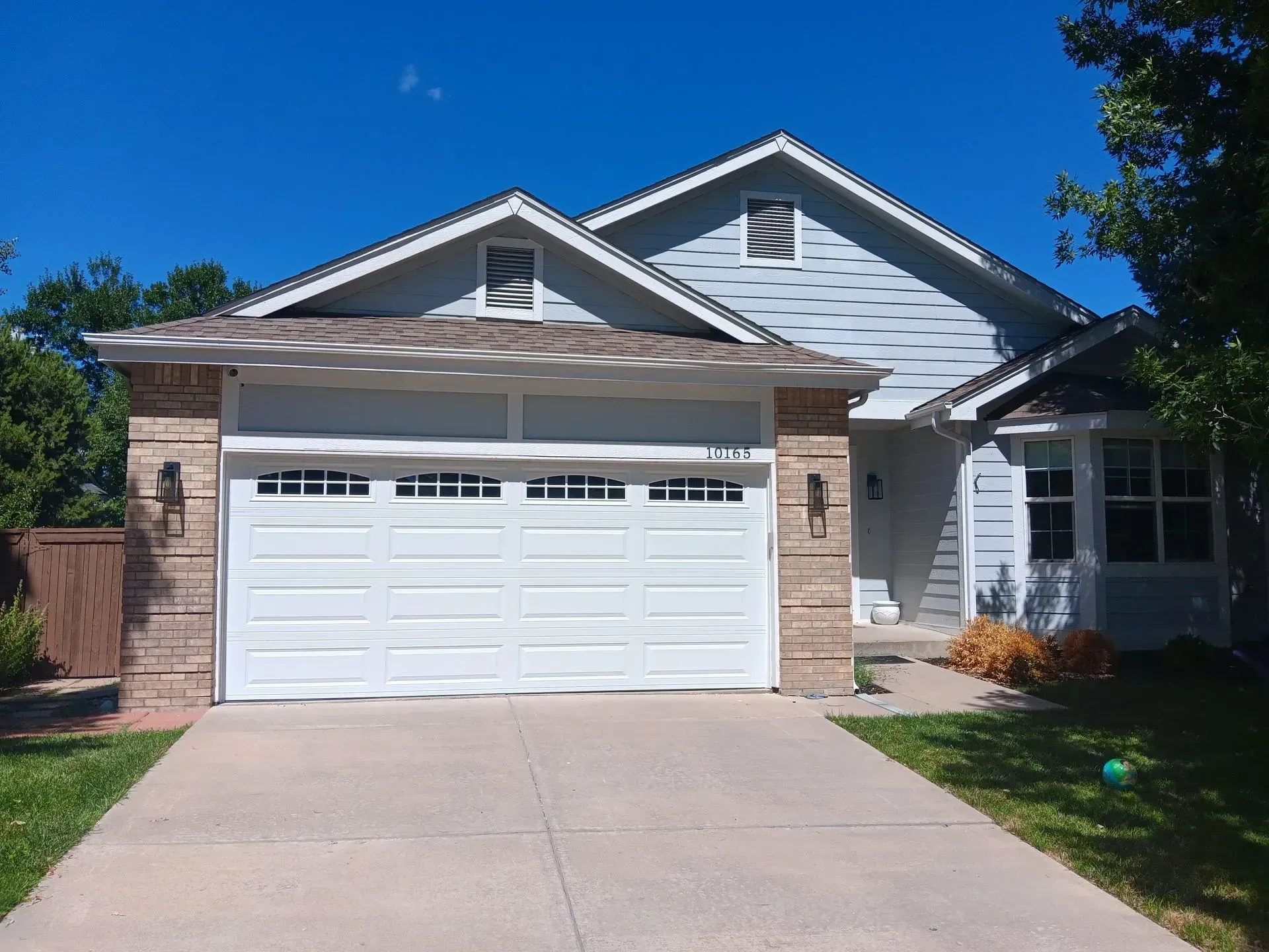 The front of a house with a white garage door