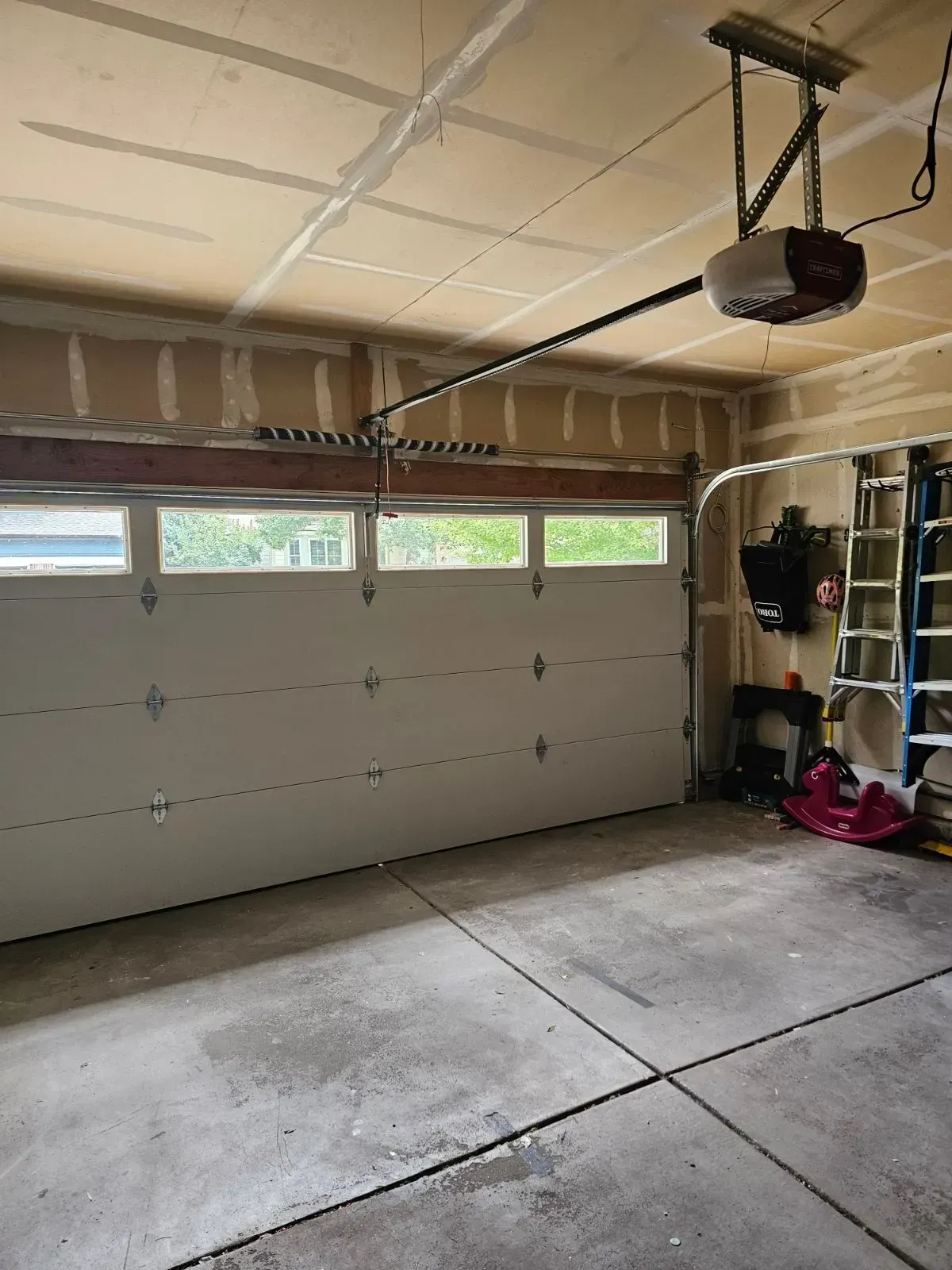 A garage with a garage door open and a garage door opener.