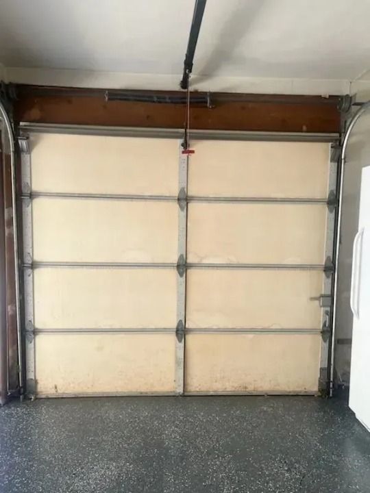 A before picture of a garage door in a garage.