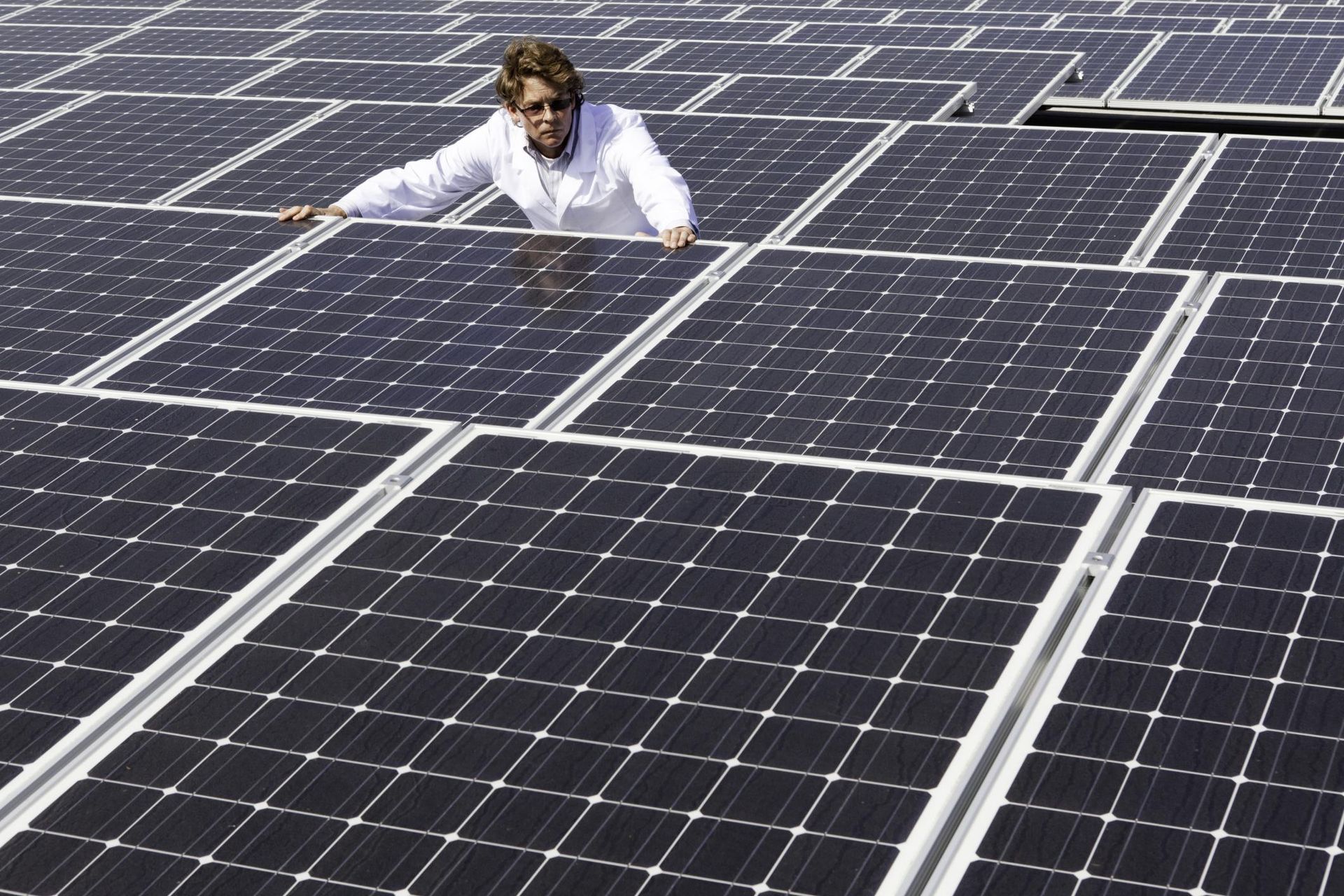 a man standing on top of a solar panel