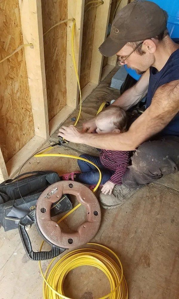 Baby and father holding wire | Middleburg, PA | Zechman Well Drilling