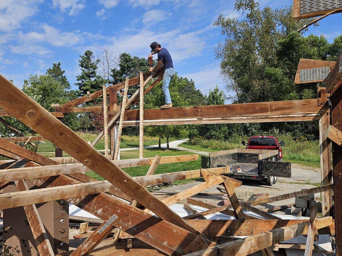 A man is standing on top of a wooden structure.