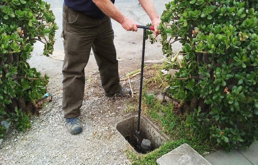 A man is digging a hole in the ground with a shovel.