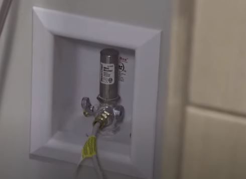 A close up of a gas hose connected to a wall.