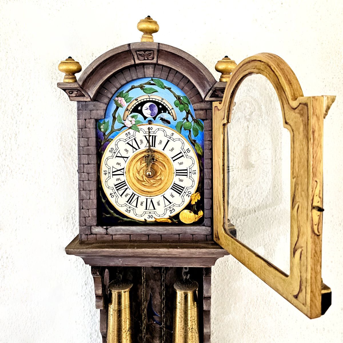 Oude hangklok, beschilderd door  Maria Huijben vooraanzicht met geopend glasdeurtje