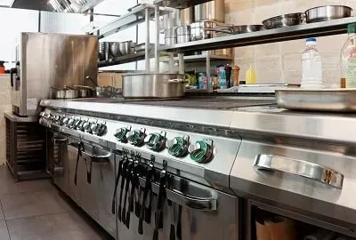 A kitchen with a lot of stainless steel appliances and pots and pans.