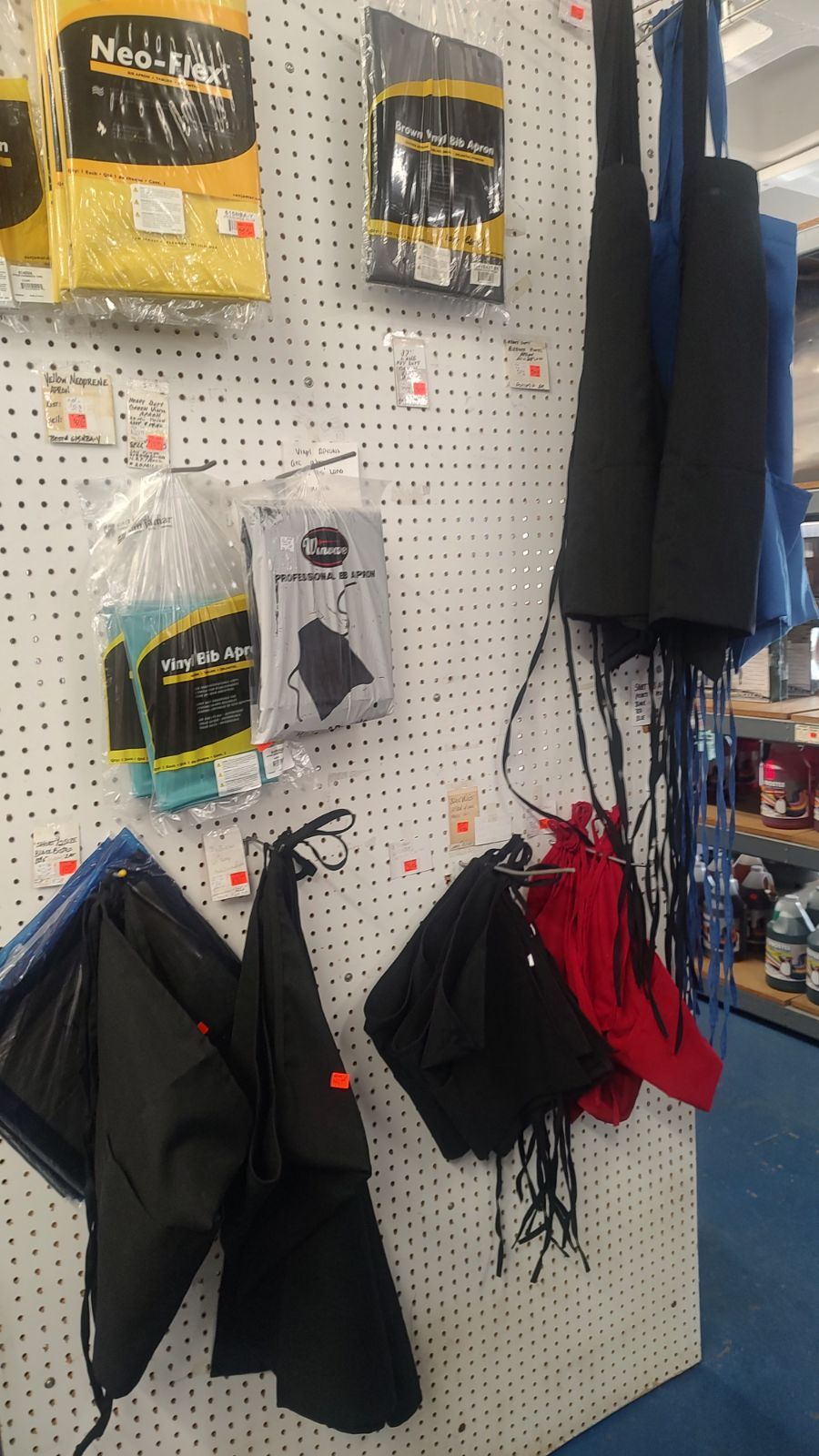 A bunch of bags are hanging on a wall in a store.