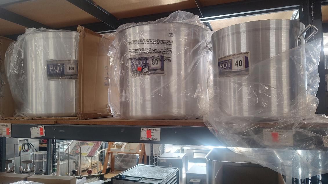 A warehouse filled with lots of pots and pans wrapped in plastic.