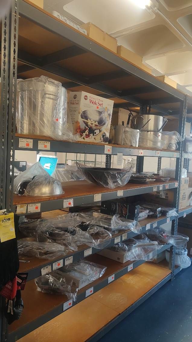 A warehouse filled with shelves filled with pots and pans.