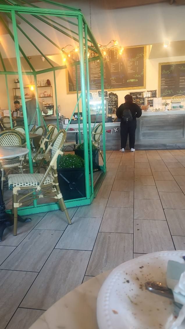 A person is standing in a greenhouse in a restaurant.